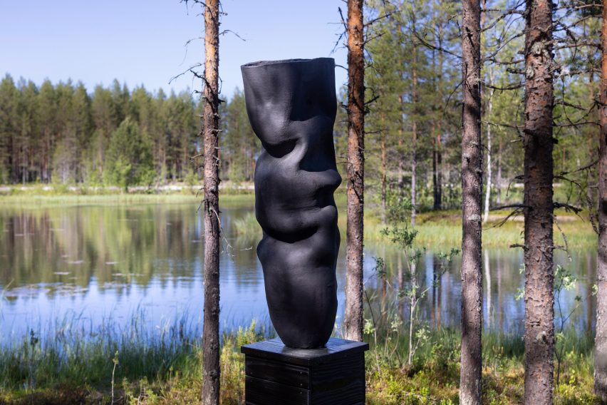 Photo of Ranti Bam's Climate Clock artwork showing a monumental black ceramic vessel sculpted with soft folds on the shore of a lake