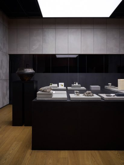 Large black-wood podiums illuminated by ceiling-mounted light boxes