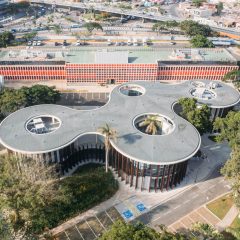 Aerial photograph showing the library's sweeping concrete canopy punctured by circular openings around preserved trees