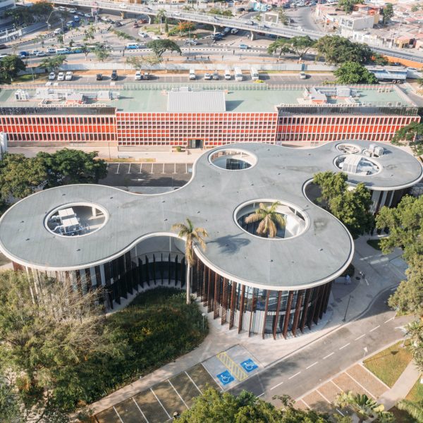 Aerial photograph showing the library's sweeping concrete canopy punctured by circular openings around preserved trees
