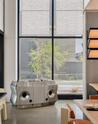 A custom stainless steel DJ booth sits at the apex of sight lines in two directions