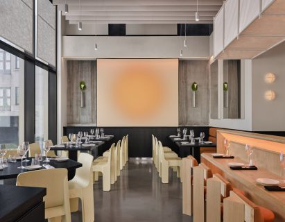 A main dining area arranged symmetrically around glowing wall-mounted artwork