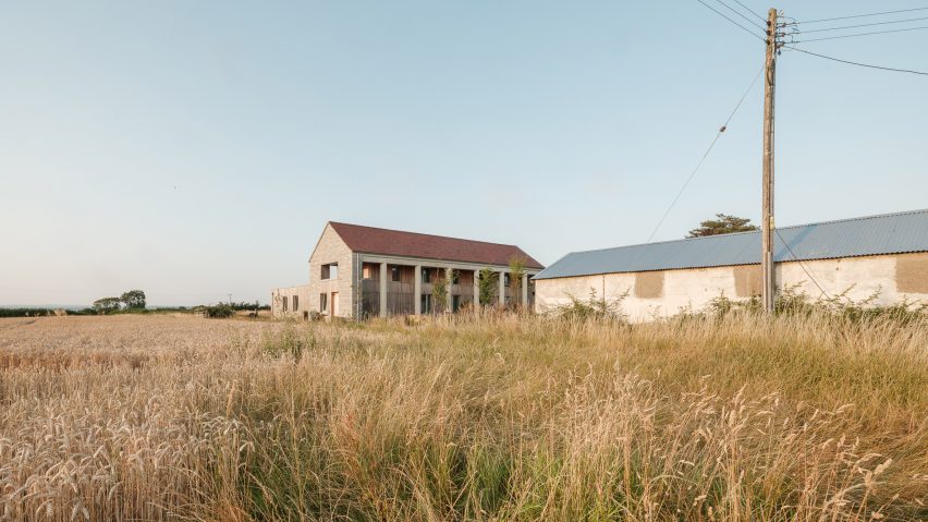 The Linhay in rural Somerset fields, showing the farmhouse-style home with a concrete colonnade, stone walls and timber cladding