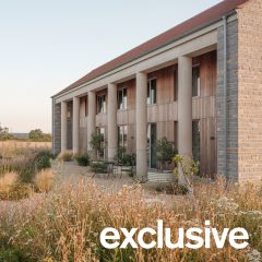 Oblique view along the length of the house showing the row of cylindrical concrete columns and landscaped garden