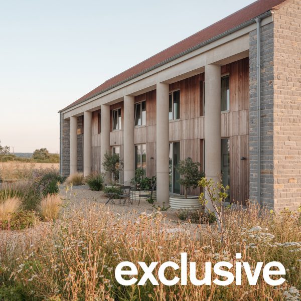 Oblique view along the length of the house showing the row of cylindrical concrete columns and landscaped garden