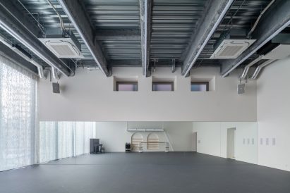 Empty ballet studio with mirrored wall, exposed steel structure and full-height curtain
