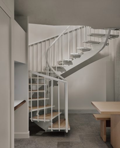 A spiral staircase leads down to a staff area in a basement