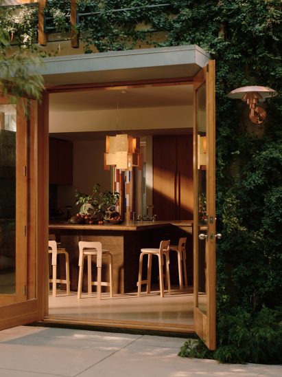 A kitchen island clad in rust-toned stone with an aged, tactile finish