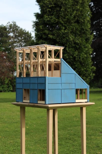 Architectural model with blue cladding and wooden structure photographed outside