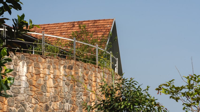 Ushas farmhouse with a red tiled roof and stone walls on a Kerala hillside