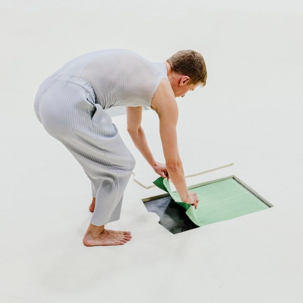 Man pulling clothes from floor