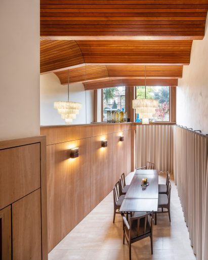 Double-height dining room with folded timber ceiling