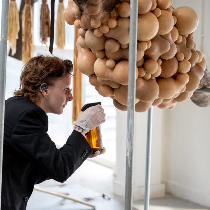 Student spraying a body-like installation