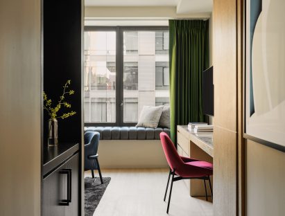 Jewel-toned fabrics enliven an otherwise neutral hotel room