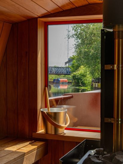 Timber-lined sauna with a large picture window overlooking the canal