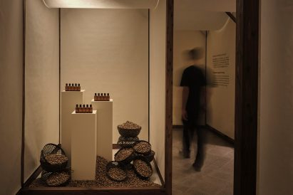 Fragrance bottles and bowls of raw ingredients displayed inside a washi paper installation