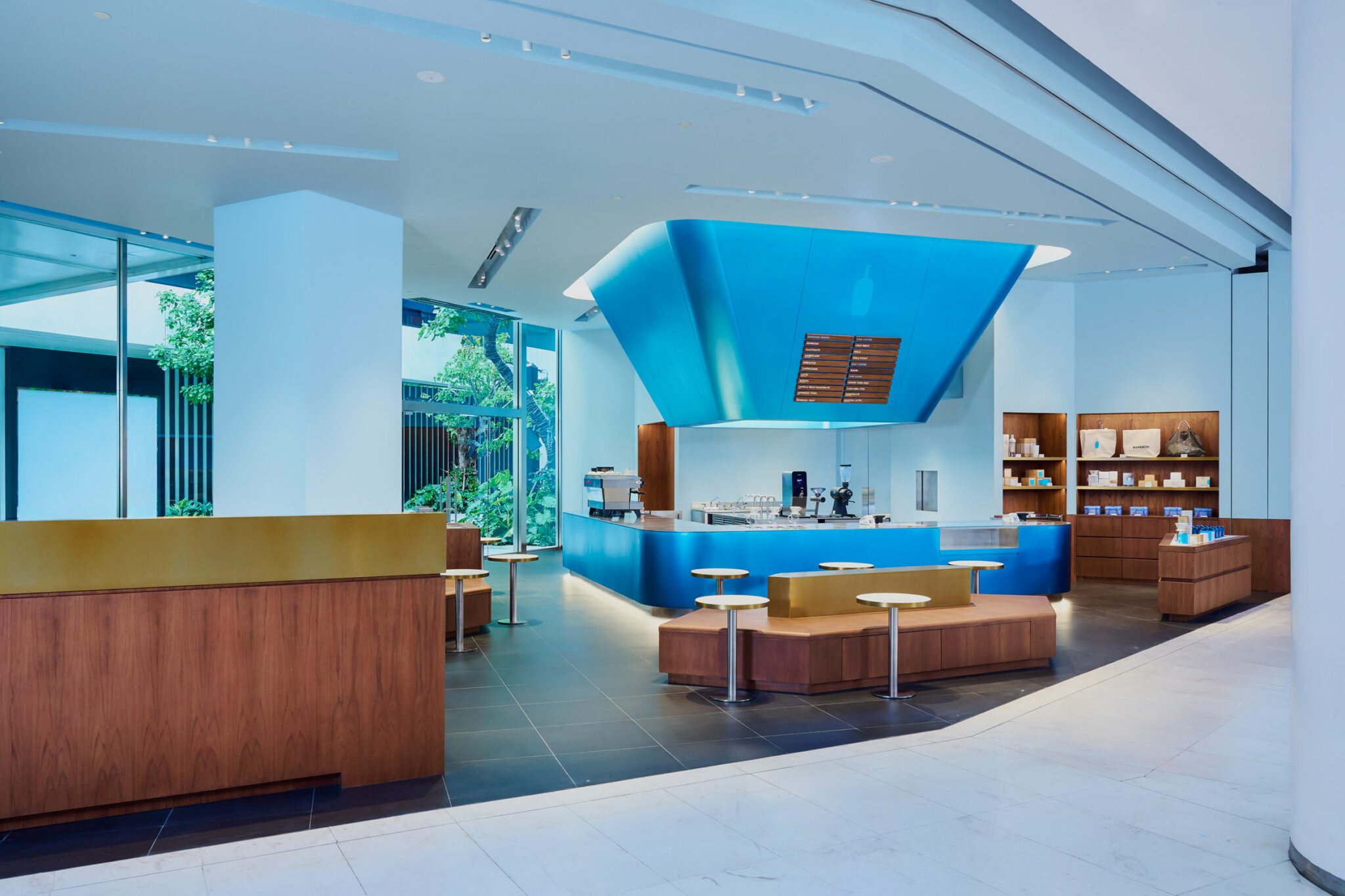 Traditional Thai lanterns inform blue and gold Bangkok cafe interior