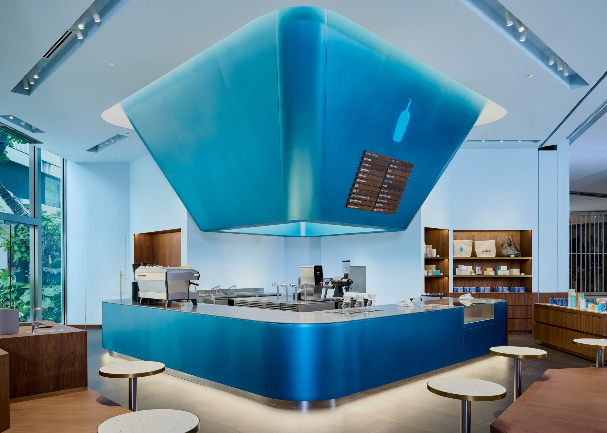 Traditional Thai lanterns inform blue and gold Bangkok cafe interior