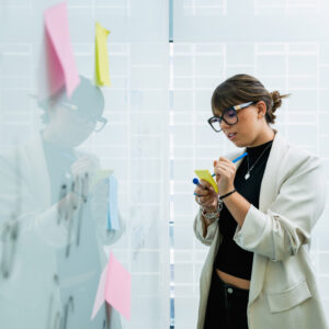 Person writing on a sticky note to add to a board