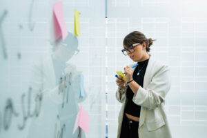 Person writing on a sticky note to add to a board