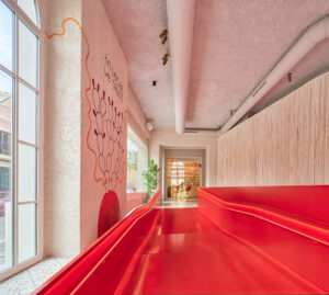 Entry with red floor in Terreno Barrio Hotel in Palma by OHLAB