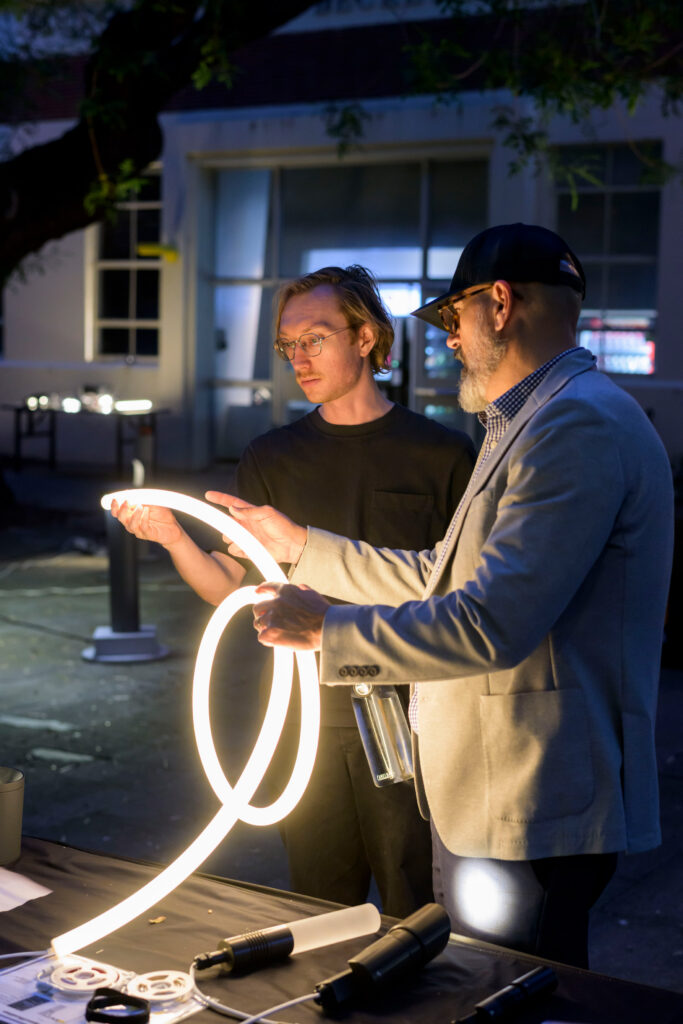people handling glowing light tube